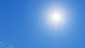 Solen skiner från en blå himmel.